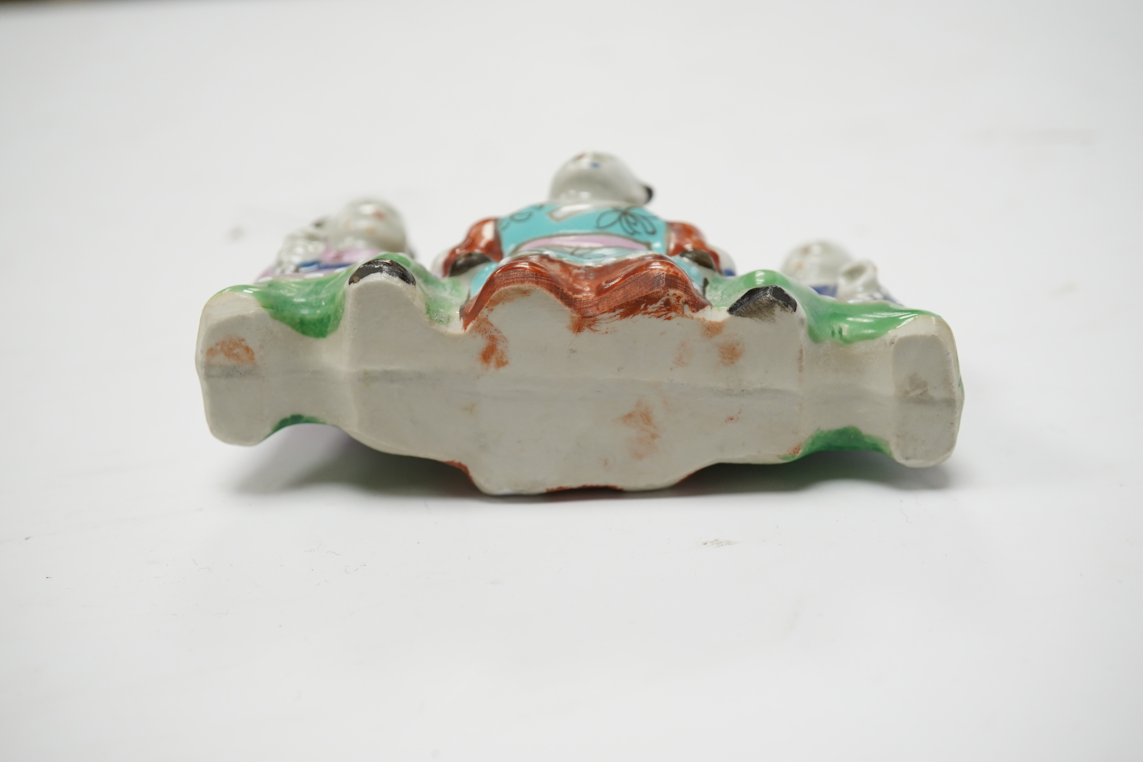 A Chinese enamelled porcelain ‘boys’ brush rest, early 19th century, 10.5cm wide. Condition - fair